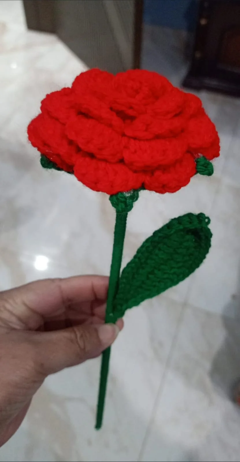 red crocheted flower with green stem