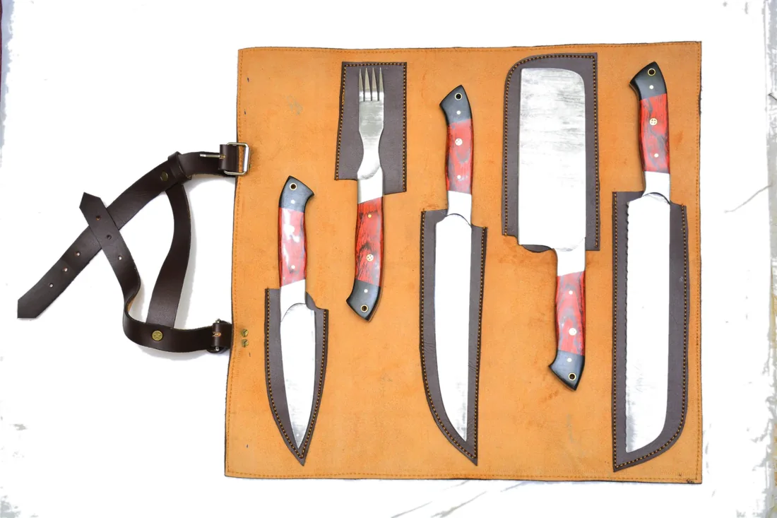 Five-piece Damascus chef knife set laid out in an open leather roll